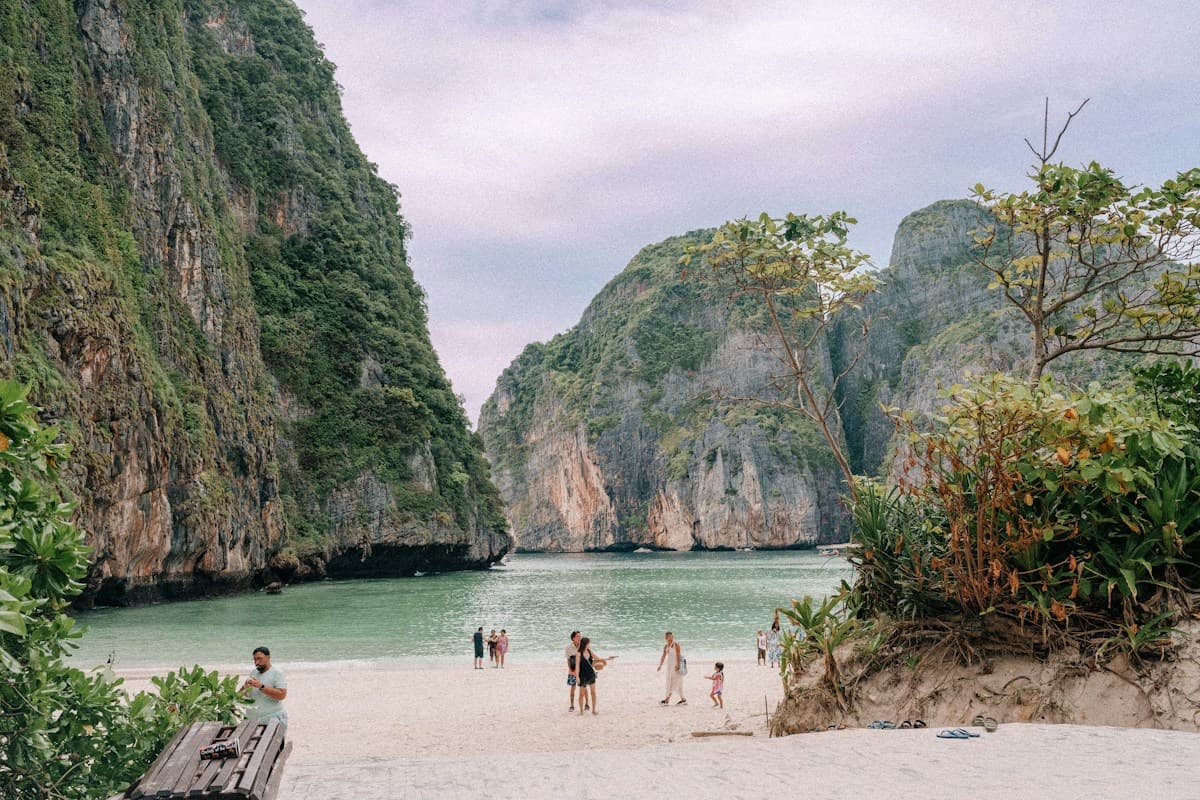 Crique de sable entourée de falaises couvertes de jungle en Thaïlande